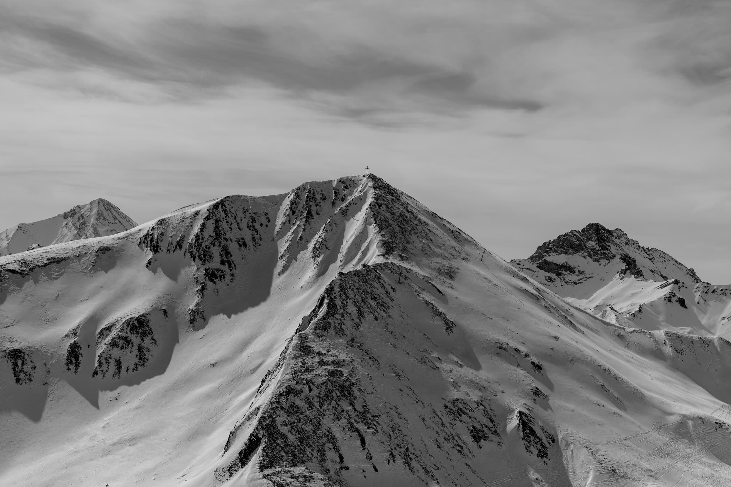 An open snow-covered summit under a bright sky