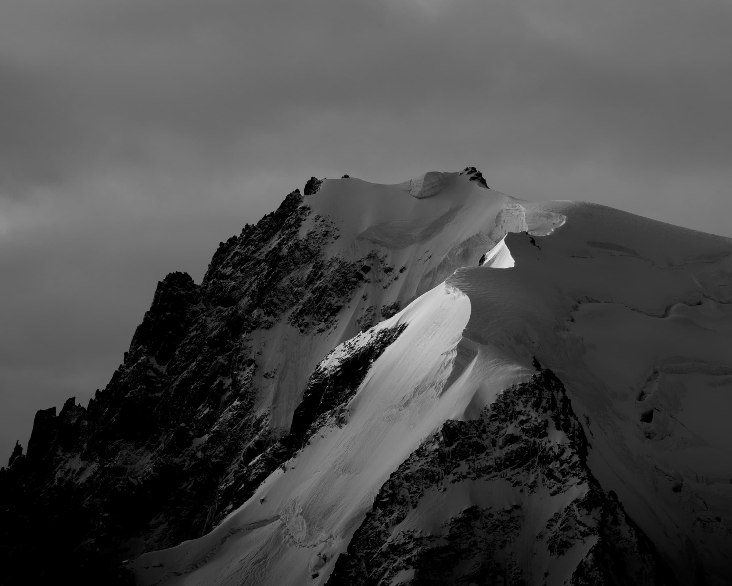 A stark black-and-white snow-laden peak